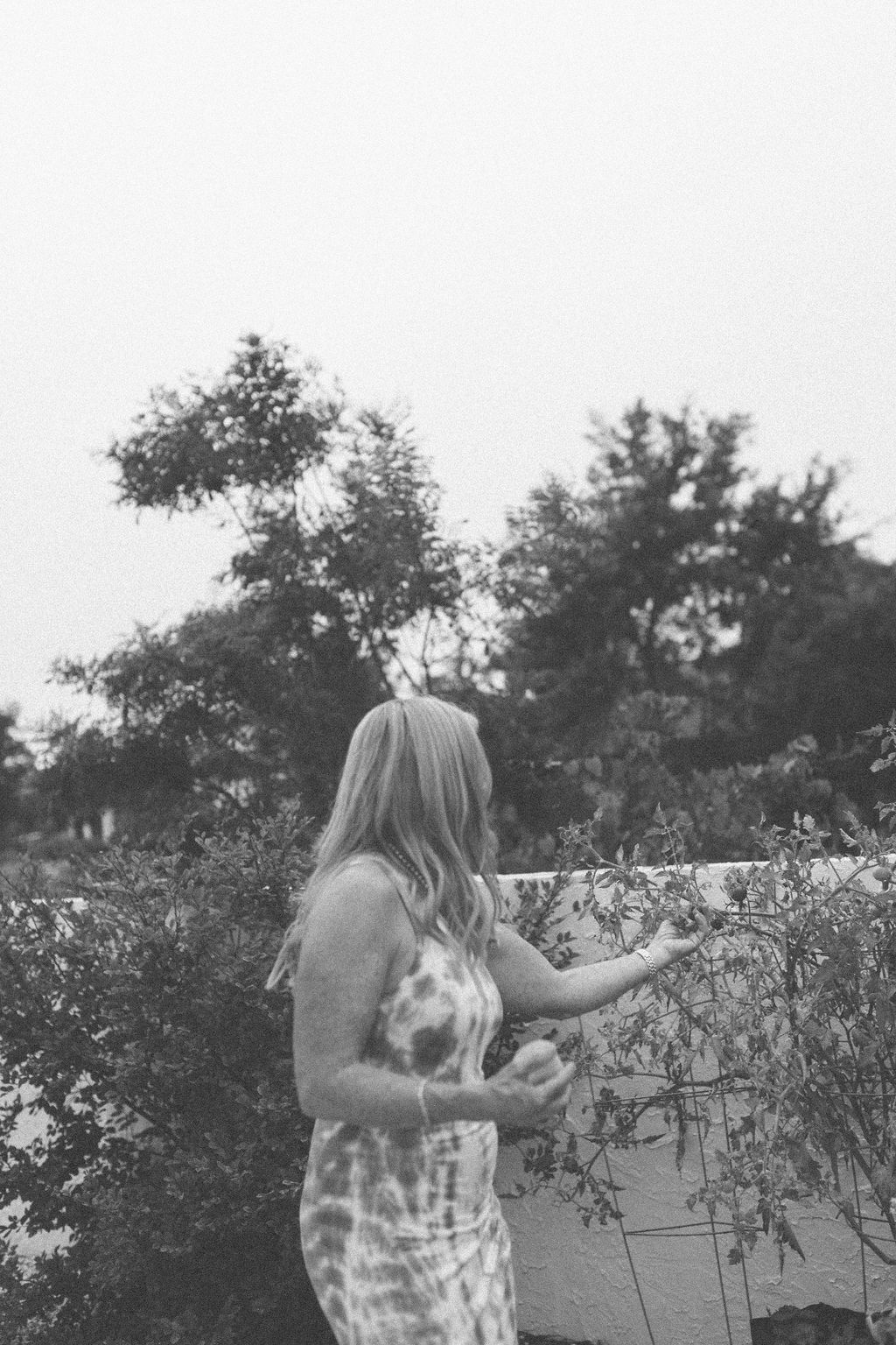 Dr. Myra Reed standing outdoors among garden greenery