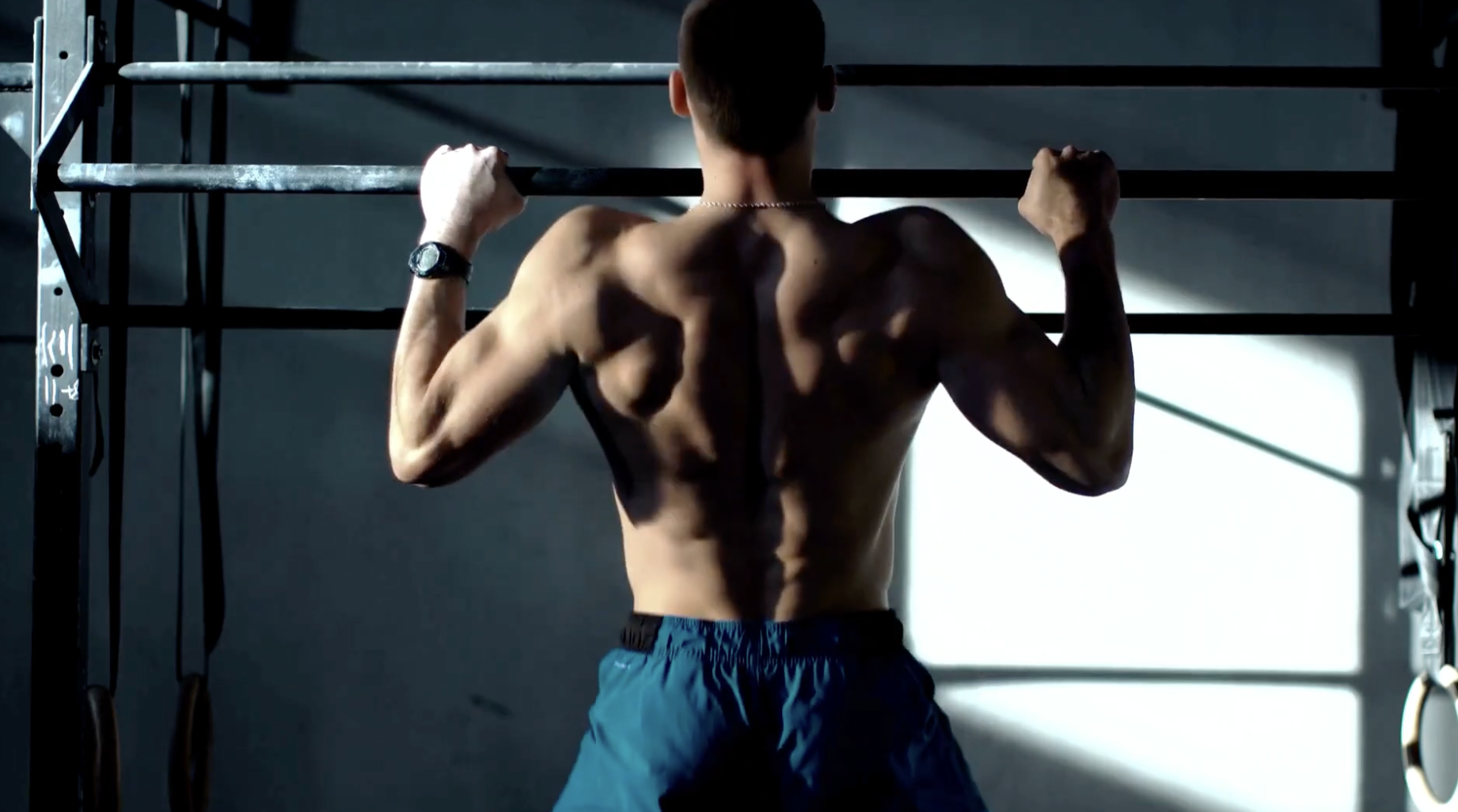 Man performing pull-ups, showing a strong muscular back